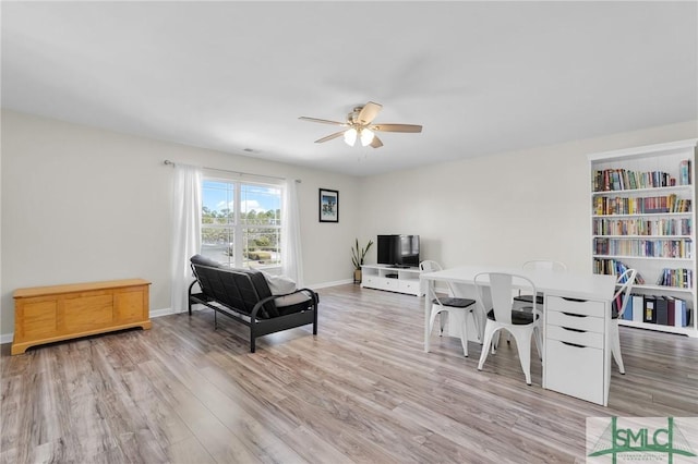 sitting room featuring ceiling fan, light wood finished floors, and baseboards