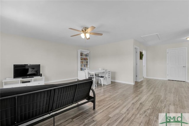 office area with attic access, ceiling fan, baseboards, and wood finished floors