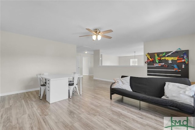 interior space with light wood-style flooring, baseboards, and a ceiling fan