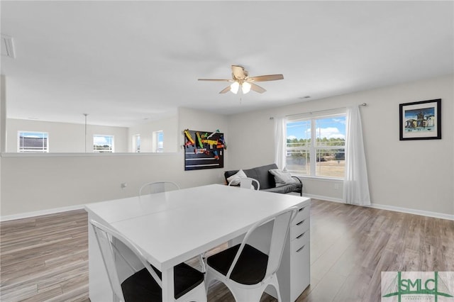 kitchen featuring a ceiling fan, light countertops, light wood-style flooring, and baseboards