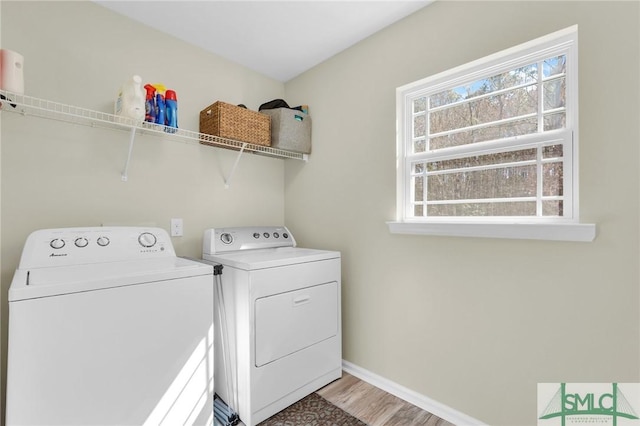 laundry room featuring baseboards, laundry area, washer and clothes dryer, and light wood-style floors