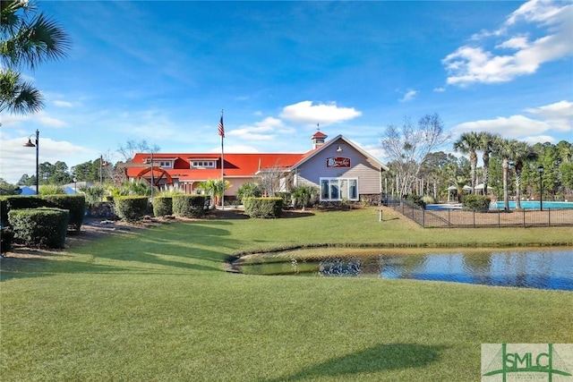 exterior space with a water view and fence