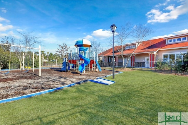 communal playground featuring fence and a lawn