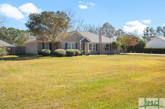 ranch-style home featuring a chimney, fence, a front lawn, and brick siding