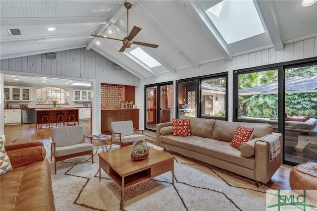 sunroom / solarium with lofted ceiling with skylight, a healthy amount of sunlight, ceiling fan, and visible vents