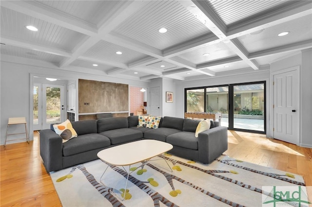 living room featuring light wood-style floors, coffered ceiling, and beamed ceiling