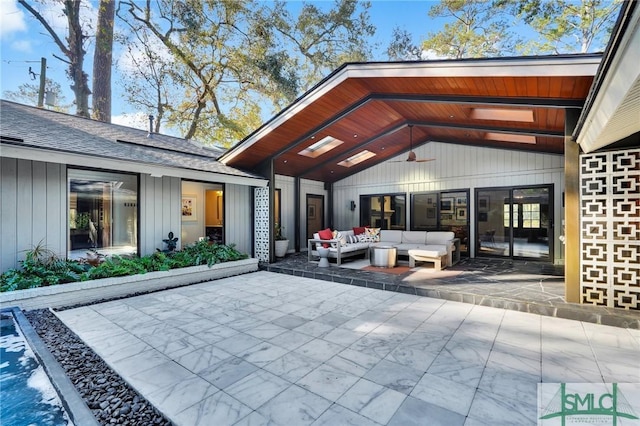 doorway to property featuring a patio, roof with shingles, and outdoor lounge area