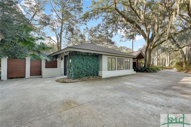 view of property exterior featuring concrete driveway and brick siding