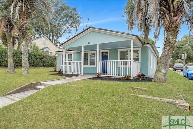 bungalow-style home featuring covered porch and a front lawn