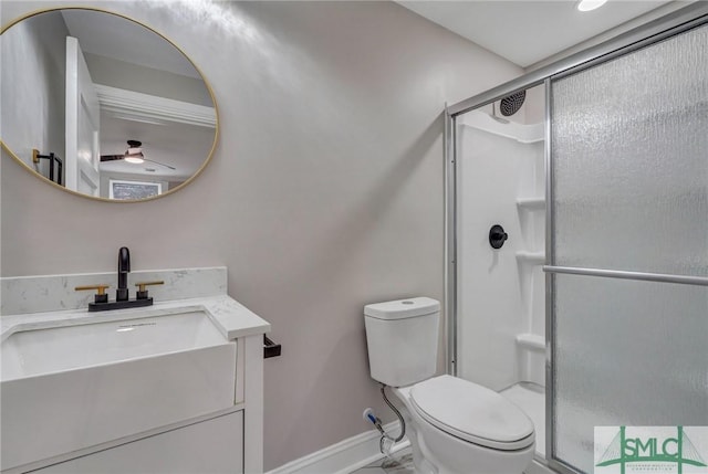 bathroom with baseboards, a shower stall, toilet, and vanity