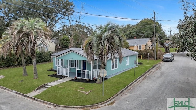 bungalow-style house featuring covered porch, metal roof, a standing seam roof, and a front yard