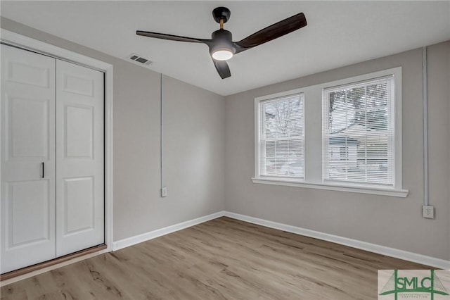 unfurnished bedroom featuring light wood-type flooring, visible vents, baseboards, and multiple windows