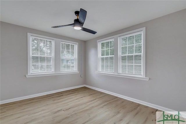 unfurnished room featuring ceiling fan, wood finished floors, and baseboards