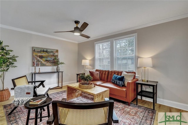 living room featuring baseboards, wood finished floors, a ceiling fan, and crown molding