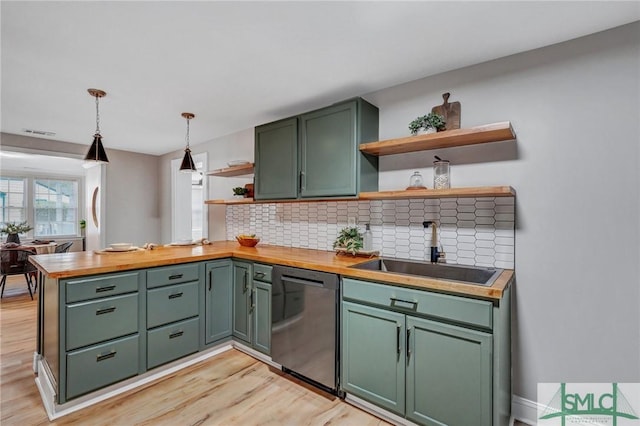 kitchen featuring a sink, dishwasher, green cabinets, and open shelves