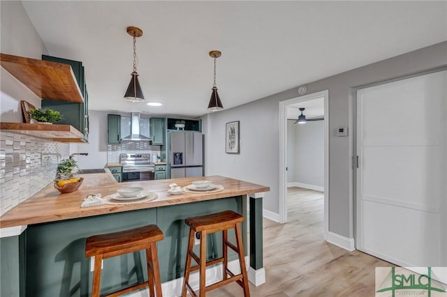 kitchen featuring decorative backsplash, fridge with ice dispenser, wood counters, wall chimney range hood, and stainless steel electric range