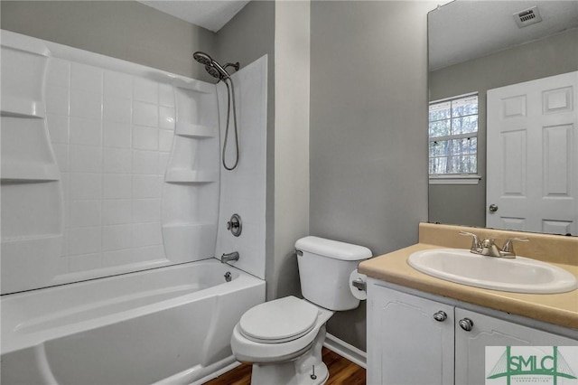 full bath featuring visible vents, toilet, vanity, wood finished floors, and shower / bathtub combination