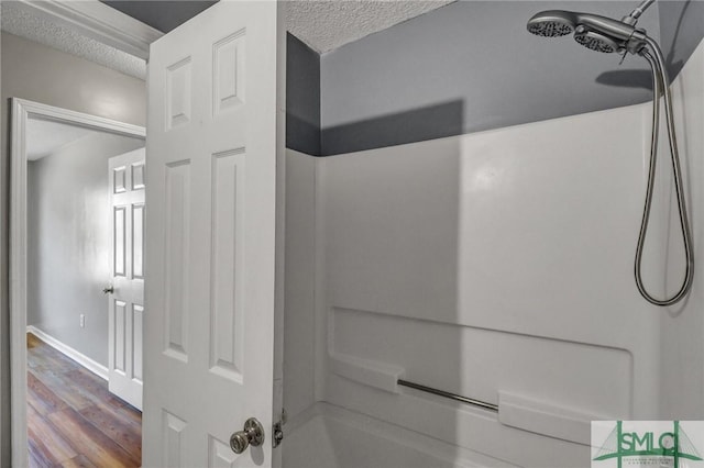 bathroom with a shower, a textured ceiling, and wood finished floors