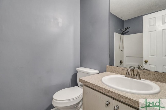 bathroom featuring a shower, vanity, toilet, and a textured ceiling