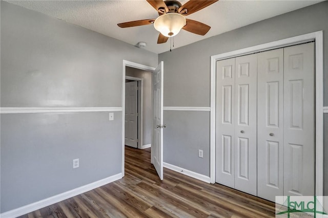 unfurnished bedroom with baseboards, ceiling fan, wood finished floors, a textured ceiling, and a closet