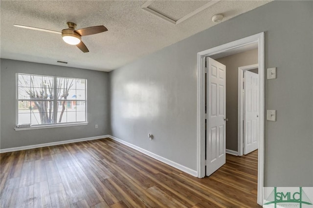 spare room with baseboards, visible vents, ceiling fan, dark wood-style flooring, and a textured ceiling