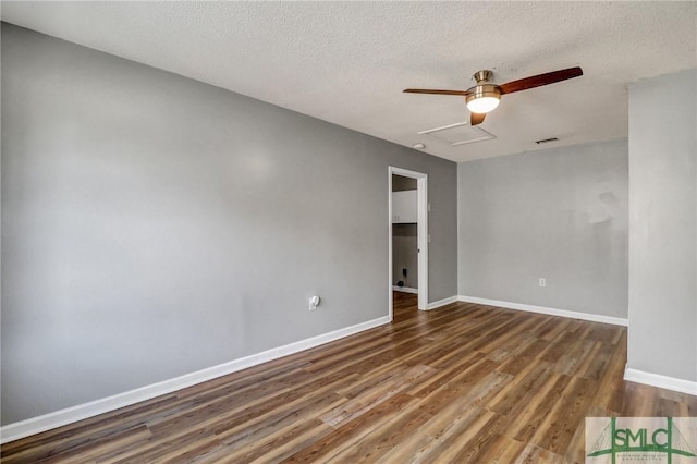 empty room featuring attic access, visible vents, baseboards, and wood finished floors