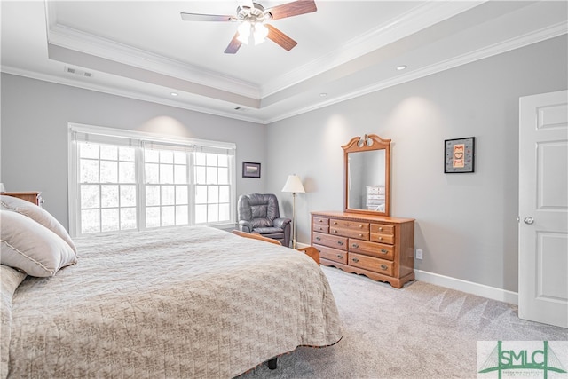 bedroom with light carpet, visible vents, a tray ceiling, and baseboards