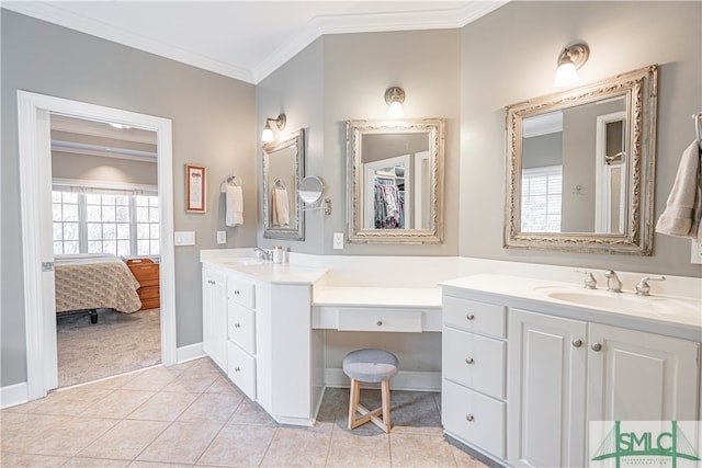 ensuite bathroom featuring ornamental molding, two vanities, tile patterned flooring, and a sink