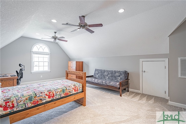 carpeted bedroom featuring a ceiling fan, vaulted ceiling, a textured ceiling, and baseboards