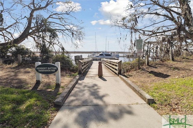 surrounding community with a dock and a water view