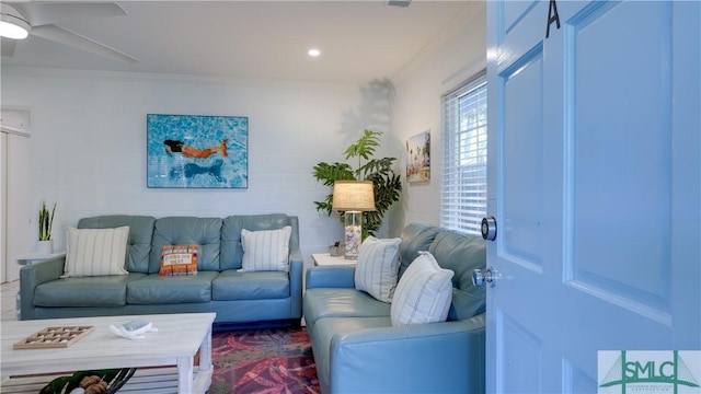 living room featuring a ceiling fan and crown molding