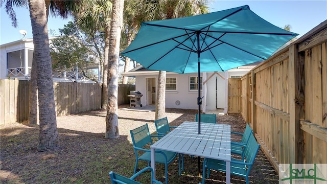 exterior space with a fenced backyard, a patio, and outdoor dining space