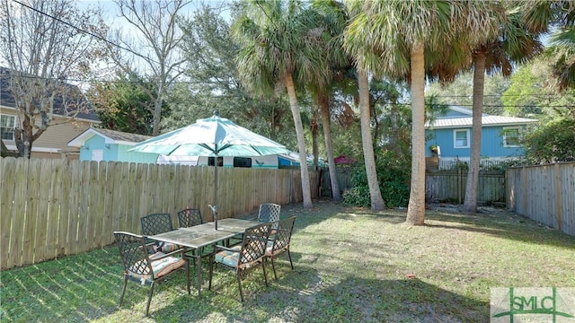 view of yard with a fenced backyard and outdoor dining space