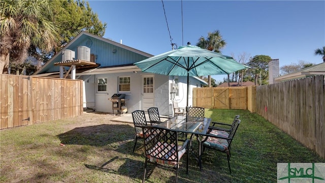 back of house featuring a fenced backyard and a yard