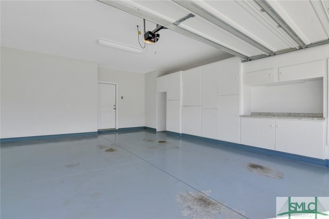 garage with a garage door opener and baseboards