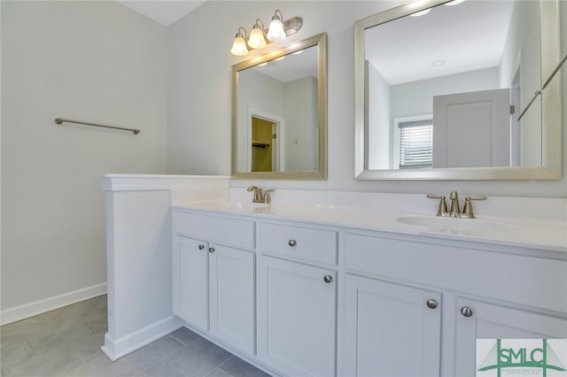 bathroom with double vanity, tile patterned flooring, baseboards, and a sink