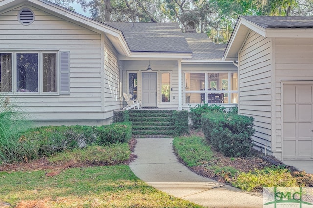 entrance to property featuring roof with shingles