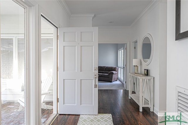 hallway featuring a healthy amount of sunlight, dark wood-type flooring, baseboards, and ornamental molding