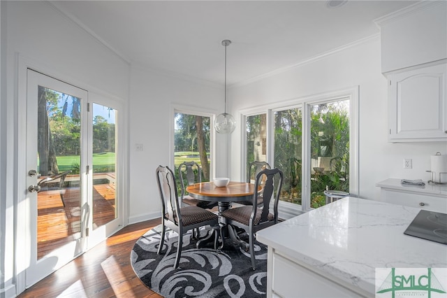 dining room with wood finished floors, a wealth of natural light, and ornamental molding