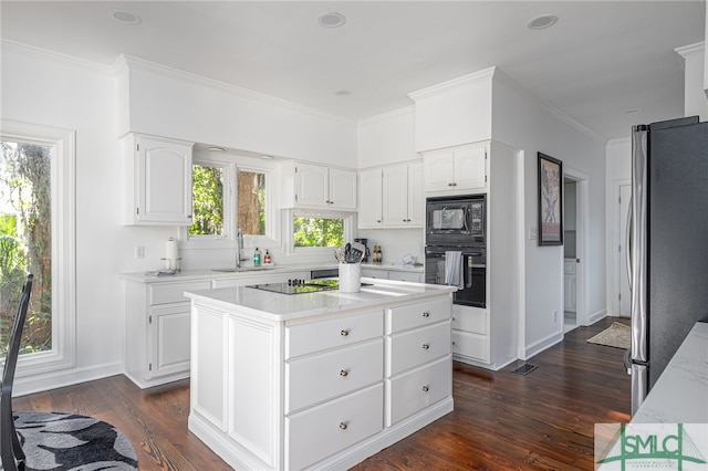 kitchen featuring black appliances, ornamental molding, a sink, dark wood finished floors, and white cabinetry