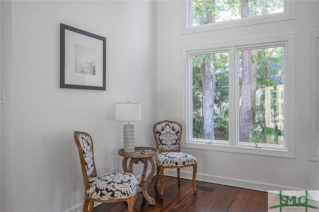 living area with visible vents, baseboards, and wood finished floors