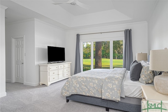 bedroom with access to exterior, crown molding, baseboards, carpet floors, and a raised ceiling