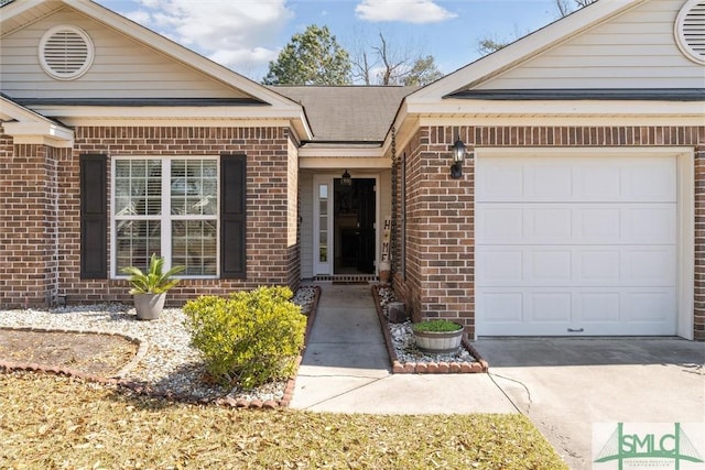 property entrance with a garage, concrete driveway, and brick siding