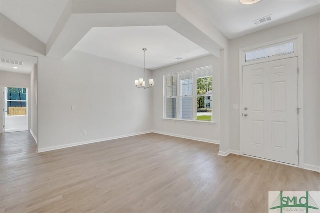 foyer entrance with light wood-type flooring, visible vents, a notable chandelier, and baseboards