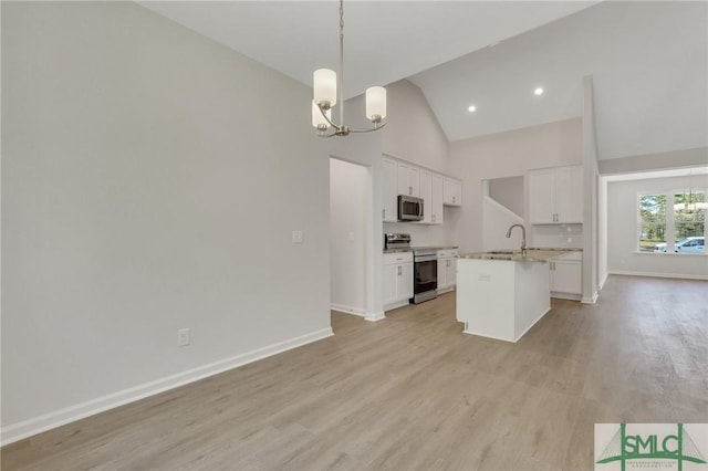 kitchen with stainless steel appliances, light wood-style flooring, an inviting chandelier, white cabinets, and a sink