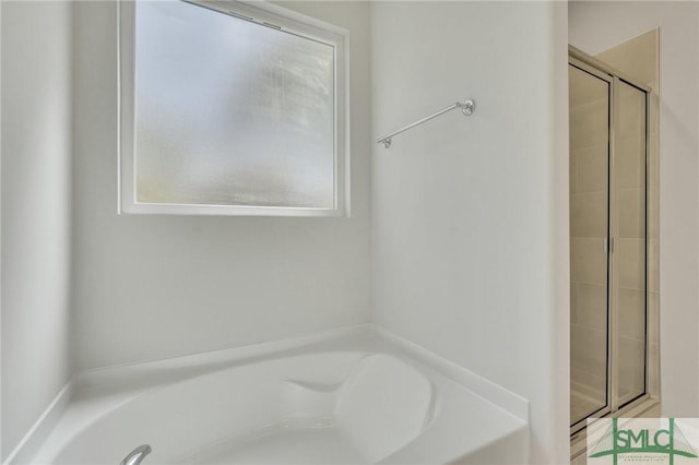 full bath with a garden tub and tiled shower