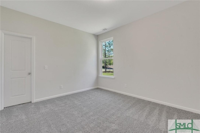 carpeted spare room featuring visible vents and baseboards