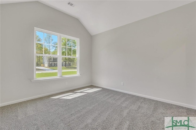 spare room featuring carpet, visible vents, lofted ceiling, and baseboards