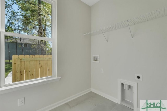 clothes washing area featuring washer hookup, electric dryer hookup, laundry area, baseboards, and tile patterned floors