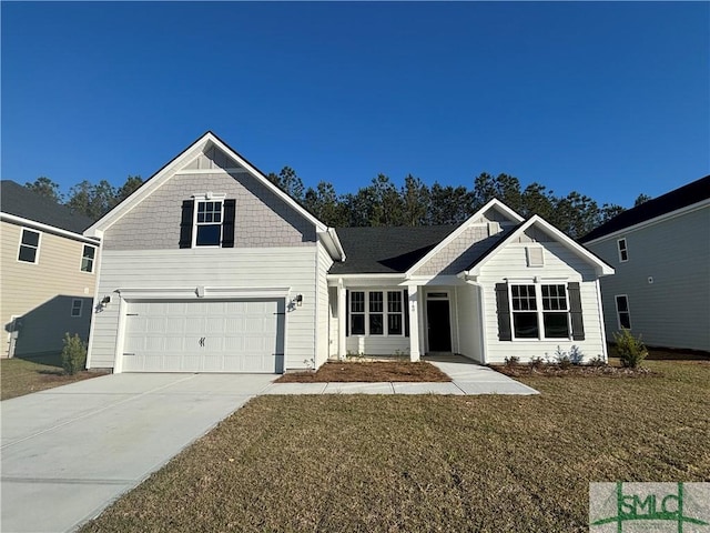 view of front of property featuring a garage, driveway, and a front yard